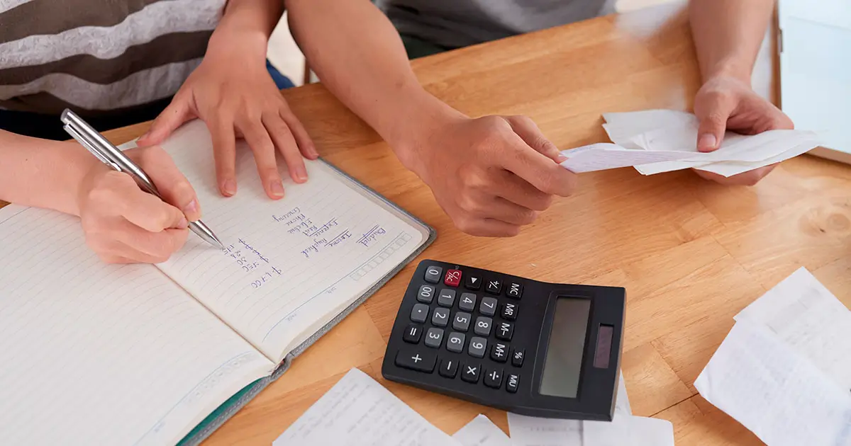 Cálculo das verbas rescisórias com documentos e calculadora sobre a mesa